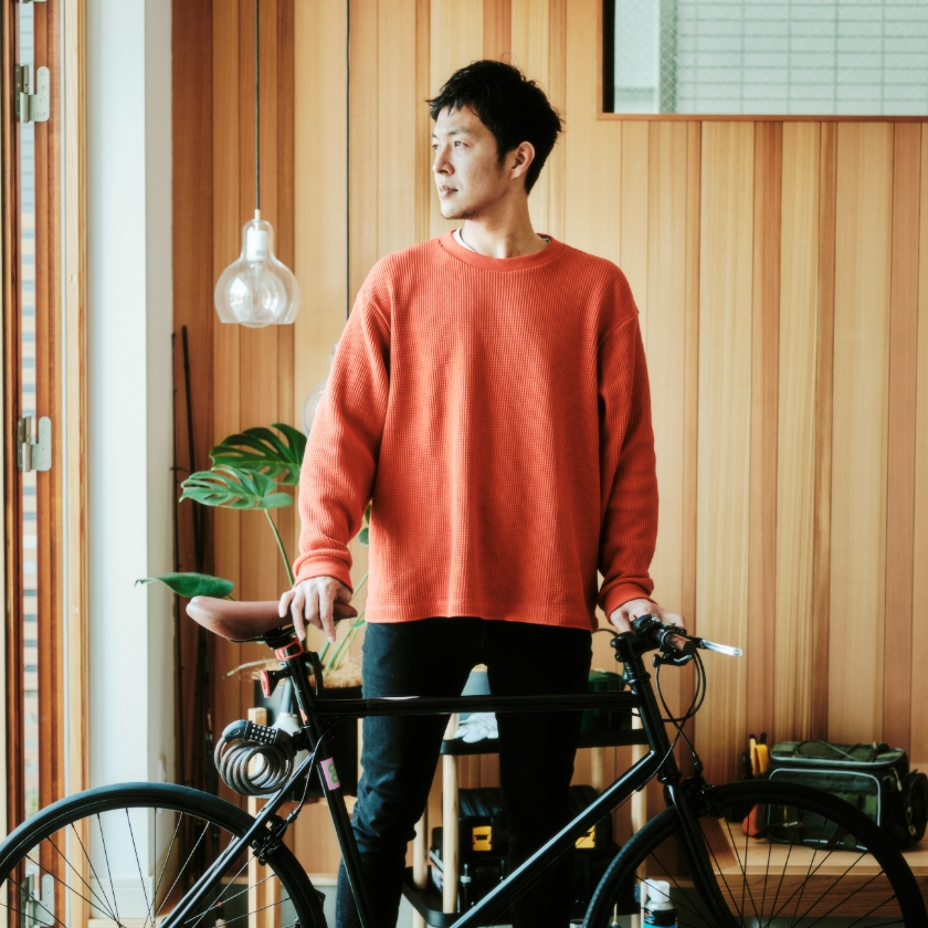 自転車をガレージキャビンに運び込む半田さん
