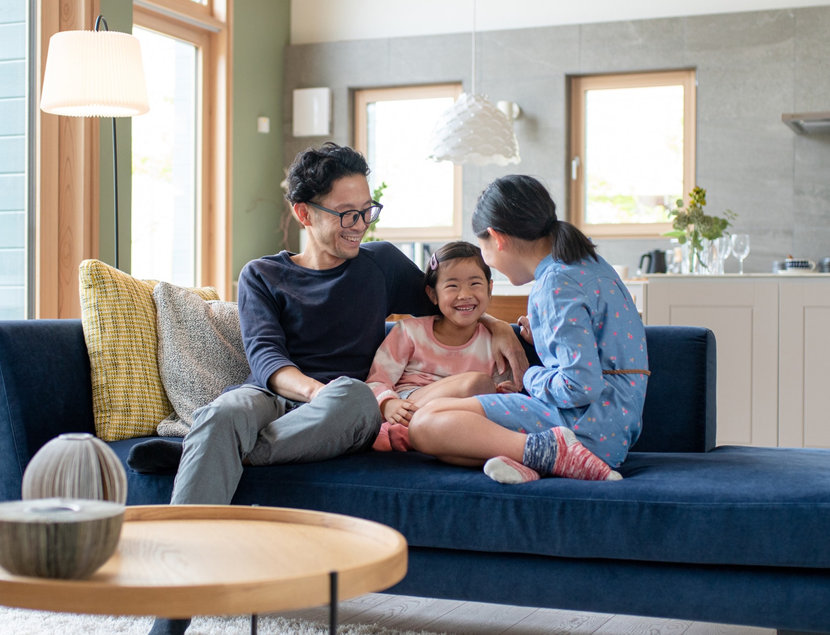 家族3人でソファにくつろいでいるイメージ