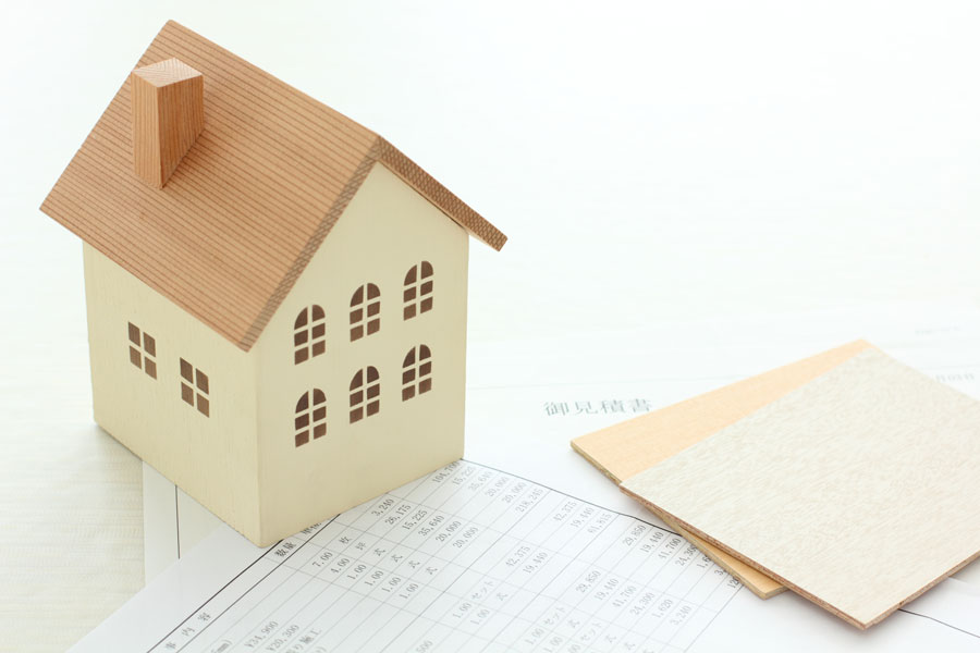 住宅の設計図の上に、家の模型が置かれている