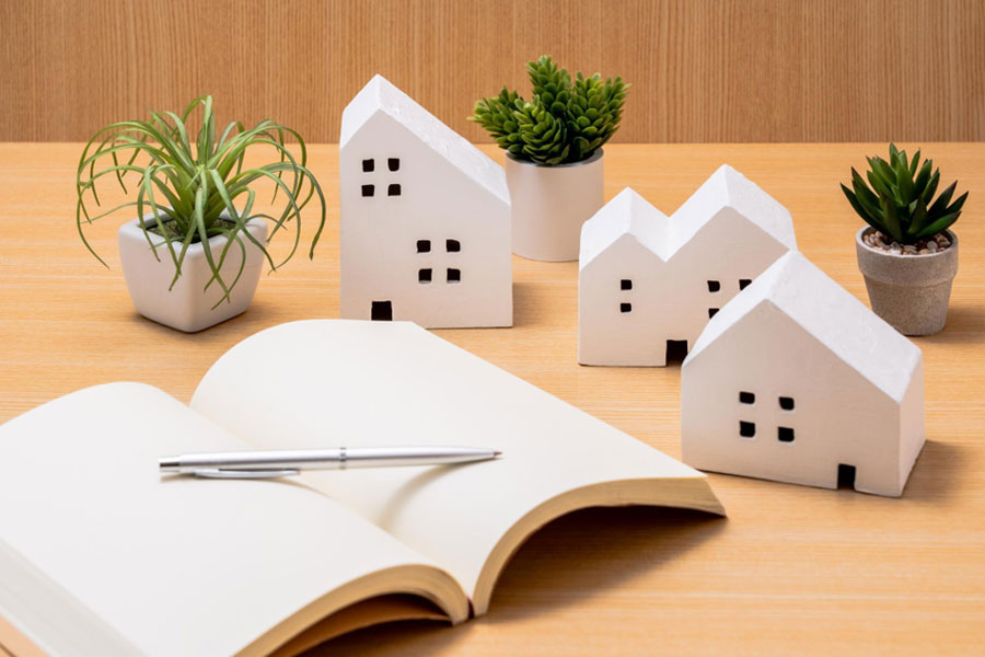 ノートとペン、複数の住宅の模型