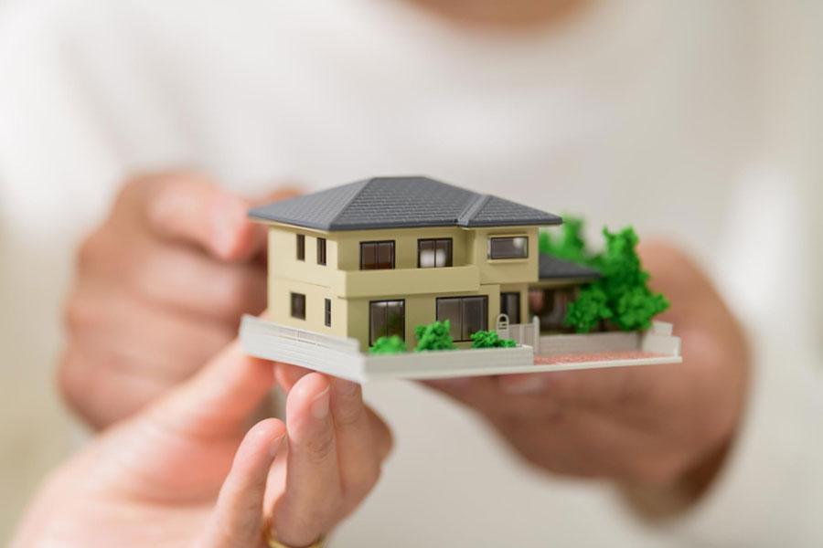 住宅の模型を持つ2人の手