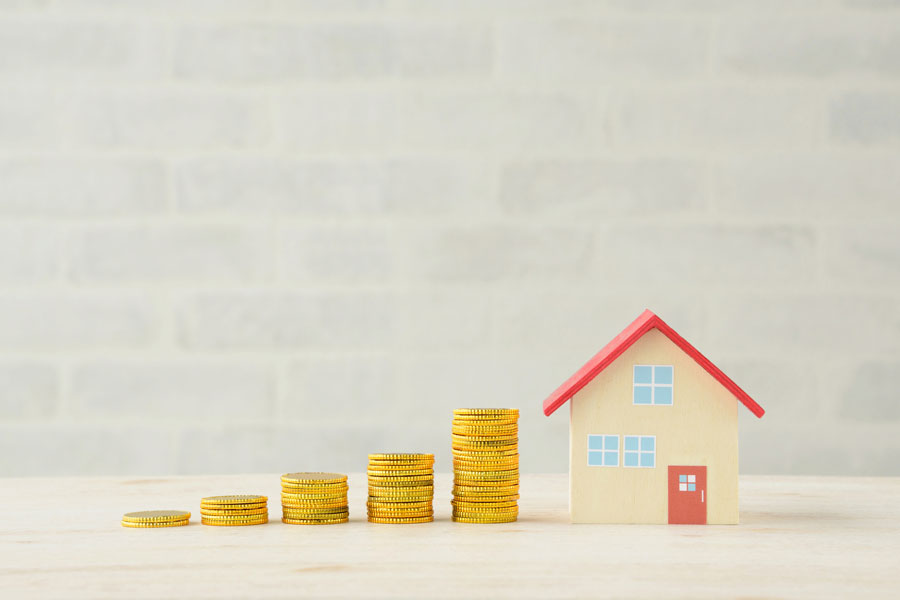 住宅の模型と5列に積み上げられたコイン
