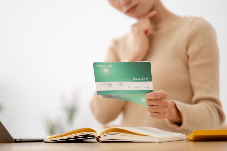 通帳を眺めながら考える人