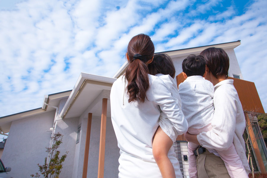 家を眺める家族