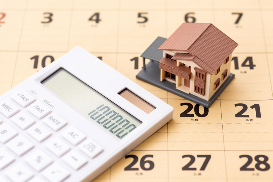 カレンダーの上にある電卓と家の模型