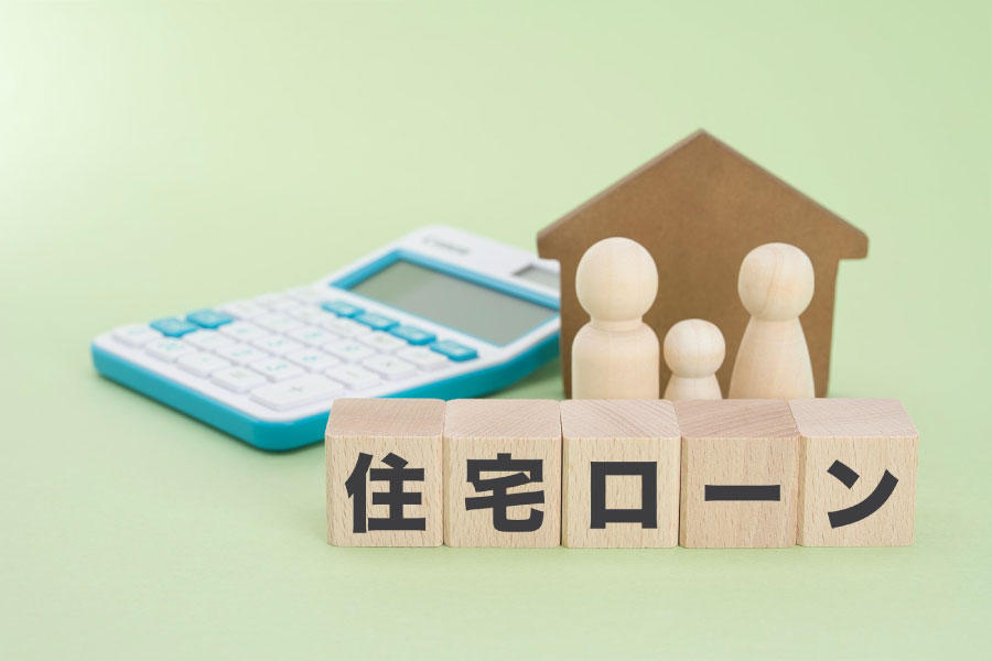 電卓とノート・住宅の模型を見ながらマイホーム計画を立てる2人