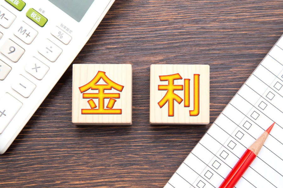 「金利」と書かれた二つのウッドブロックと電卓・チェックリスト