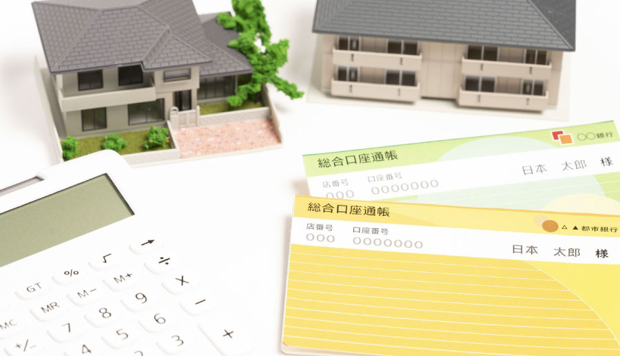 住宅の模型と電卓・通帳