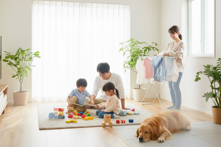 室内で家族4人と犬がくつろいでいる