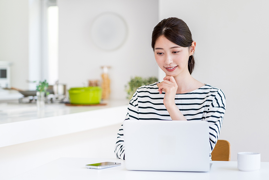 ノートパソコンでハザードマップを調べる人