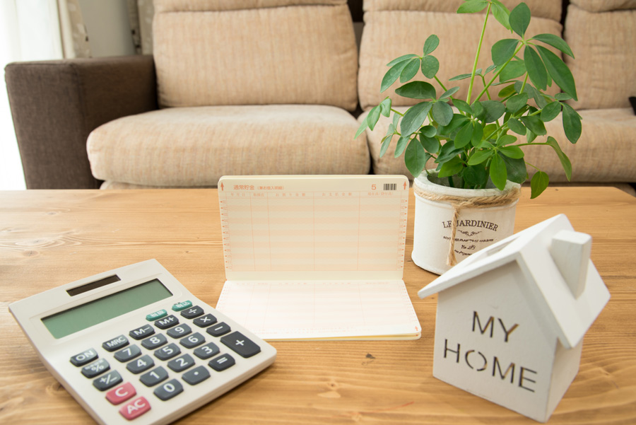 住宅の模型と通帳・電卓
